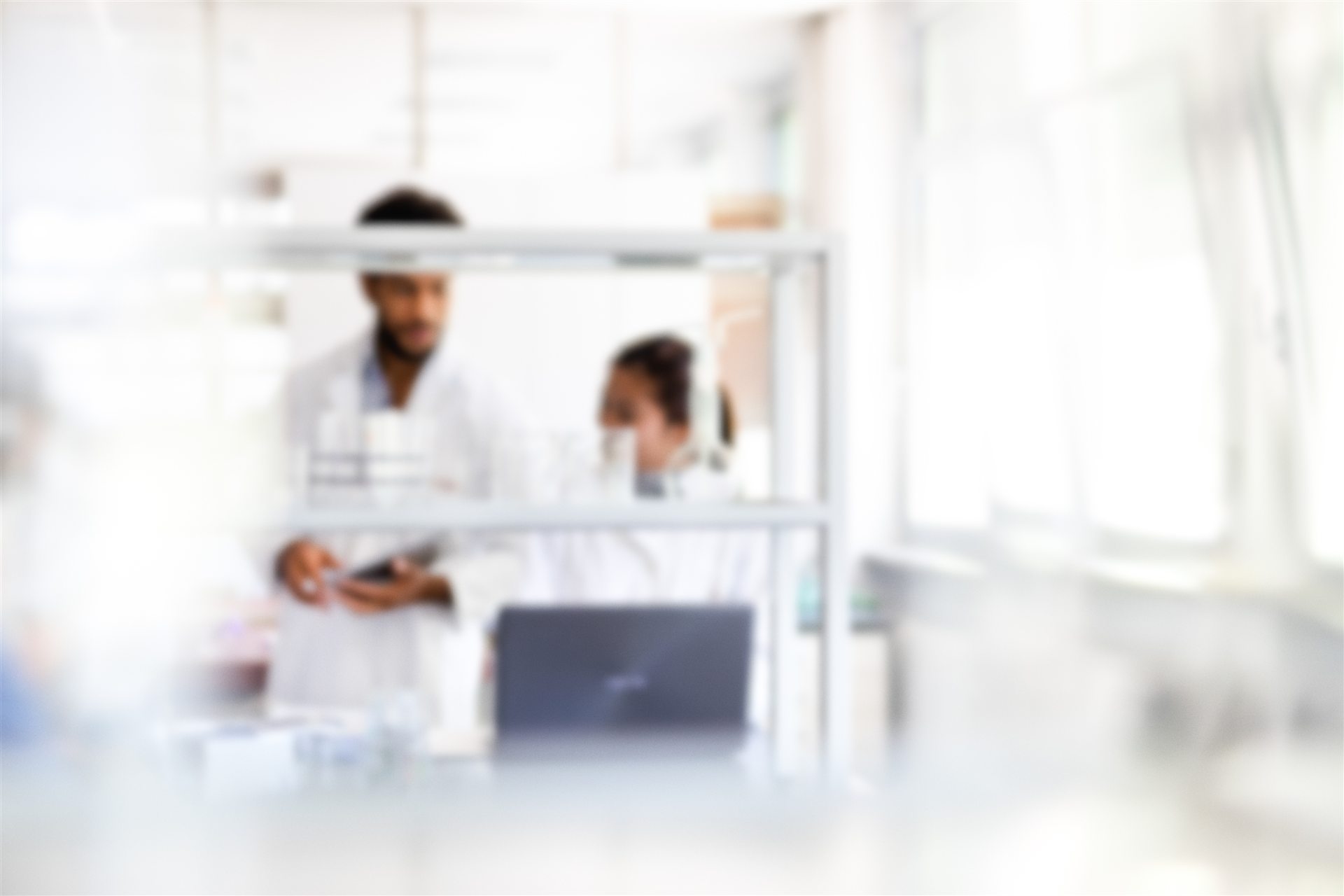 Forensic laboratory professionals behind glass used to illustrate alcohol testing quality-control review
